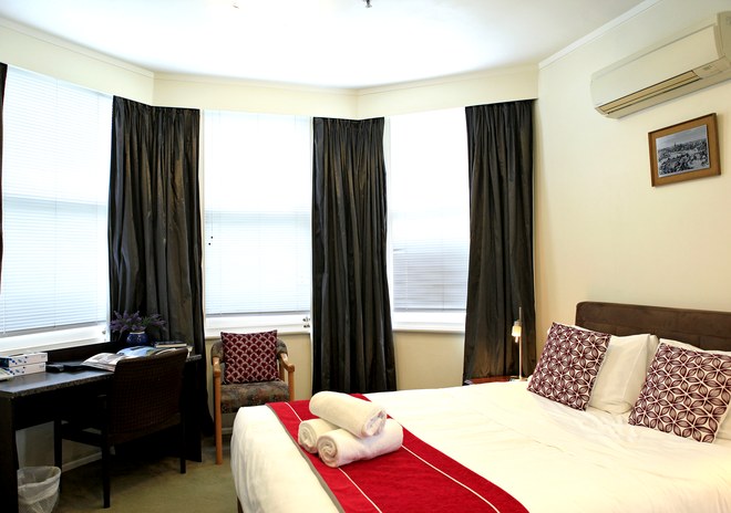 Queen Studio Room with bay windows and a queen bed